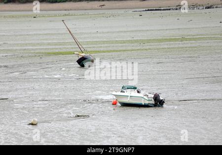Deux bateaux coincés sur le fond boueux à marée basse dans la ville de Cancale en Bretagne dans le nord de la France Banque D'Images