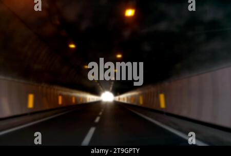 volontairement flou tunnel routier asphalté sans voitures et vous voyez la lumière au loin, idéal comme concept d'espoir Banque D'Images