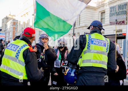 Londres, Royaume-Uni. 25 novembre 2023. Des policiers de met ont vu parler aux manifestants et leur demander de retirer leur couverture faciale pour des raisons de sécurité pendant la marche. Les partisans pro-palestiniens continuent de marcher dans le centre de Londres pour exiger un cessez-le-feu parfait de la guerre Israël-Gaza depuis que la guerre a éclaté début octobre. (Photo de Hesther ng/SOPA Images/Sipa USA) crédit : SIPA USA/Alamy Live News Banque D'Images