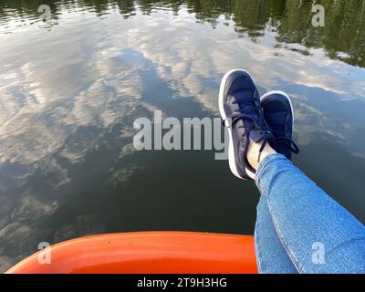 Pieds sur le bord du catamaran ou du bateau, espace copie. Personne pendante sur les pieds au-dessus de l'eau. Concept de loisirs sur la nature Banque D'Images