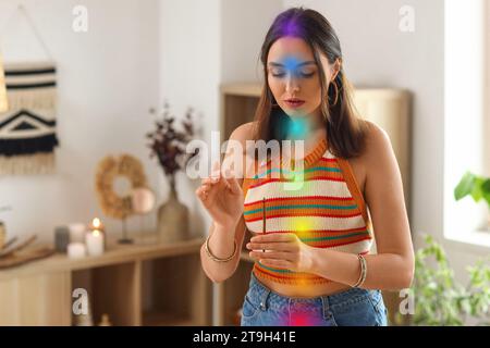 Jeune femme avec l'espace de nettoyage d'encens et aura à la maison Banque D'Images