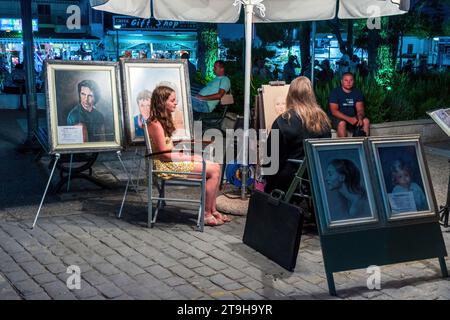 Une artiste de rue femme peint le portrait d'une fille. Chaniotis, Grèce Banque D'Images