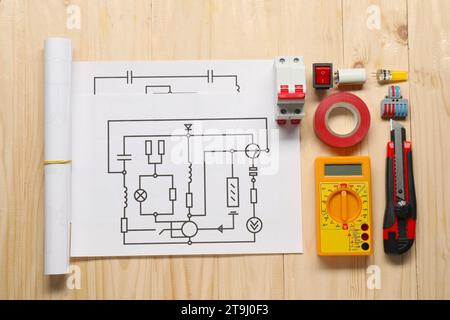 Composition à plat avec schémas de câblage et multimètre numérique sur table en bois Banque D'Images
