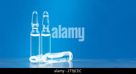 Trois ampoules médicales sur fond bleu. Concept de médicaments. Trois flacons pour injection médicale Banque D'Images