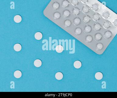 Pilules blanches, antibiotique argenté sur fond bleu, vue de dessus. Concept de soins de santé en pharmacie. Banque D'Images
