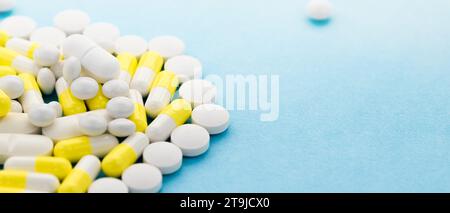 Des pilules et des capsules blanches et jaunes ont été dispersées sur la table avec un espace de copie. Médecine, remèdes pharmaceutiques fond. Coffre de médecine à domicile. Banque D'Images