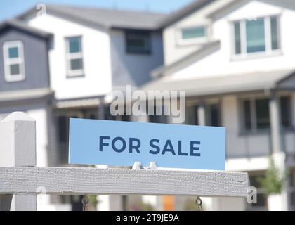 Gros plan sur le panneau à vendre devant une maison californienne. Crise du logement, maisons à vendre. Banque D'Images