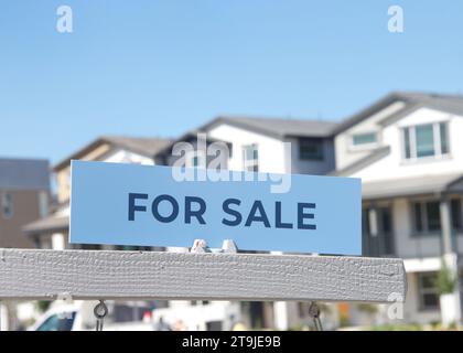 Gros plan sur le panneau à vendre devant une maison californienne. Crise du logement, maisons à vendre. Banque D'Images