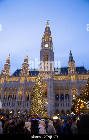 Le bâtiment Rathause décoré de lumières dorées de nuit dont la cour avant est utilisée comme un marché de Noël (Wiener Christkindlmarkt) la nuit en hiver Banque D'Images