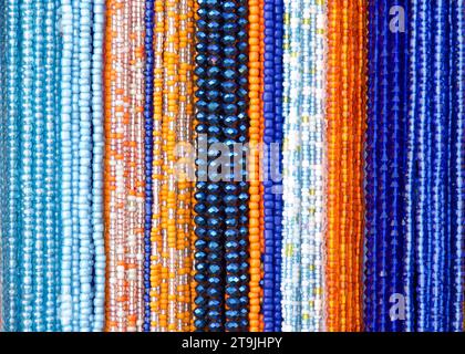 gros plan sur des cordes de perles en bleus, oranges et violets. Décorations de cheveux populaires dans certaines cultures. Banque D'Images