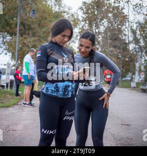 Belgrade, Serbie, le 4 novembre 2023 : deux athlètes féminines regardent un smartphone juste avant le début de la course caritative « Zajedno za Vasilija » Banque D'Images