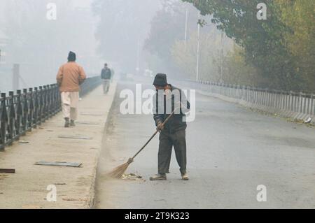 Srinagar, Inde records la nuit la plus froide de la saison 23 novembre 2023, Srinagar Cachemire, Inde : les gens marchent le long d'une route pendant un matin brumeux à Srinagar. Le Cachemire a connu des conditions météorologiques brumeuses et froides avec Srinagar enregistrant la nuit la plus froide de la saison à moins 1,8 degrés Celsius, selon le département météorologique. Srinagar Kashmir India Copyright : xFirdousxNazirxEyepixxGroupx crédit : Imago/Alamy Live News Banque D'Images