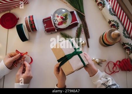 Vue de dessus de maman et fille emballant des cadeaux pour la veille de Noël. Famille heureuse passer du temps plus dur pendant les vacances d'hiver Banque D'Images