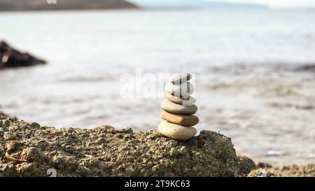 Pyramide de cairn en pierre au bord de la mer. Pile de pierres équilibrées sur la plage. Banque D'Images