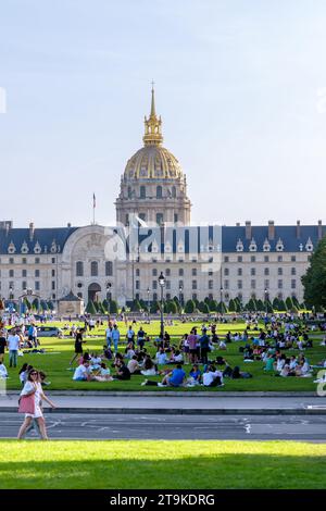 Paris, France - 8 octobre 2023 : vue d'une foule de jeunes assis en petits groupes dans un parc verdoyant devant l'Hôtel des Invalides Banque D'Images