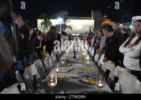 Une table de Shabbat organisée de manière festive avec des chaises vides, représentant les otages israéliens du Hamas, se tient debout alors que des dizaines de milliers de personnes assistent à un rassemblement en soutien aux 212 otages qui sont toujours détenus par le Hamas, alors que 13 autres otages israéliens ont été libérés de Gaza, au cours de la deuxième journée du cessez-le-feu le 25 novembre 2023 à tel Aviv, Israël. Au total, 50 otages actuellement détenus par le Hamas doivent être libérés au cours d'une trêve de quatre jours avec Israël Banque D'Images