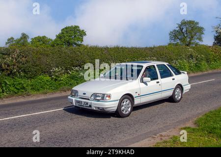 Années 1990 90 blanc British White Ford Sierra Xr4x4 I, berline à quatre portes essence 2933 cc, moteur V6 avec injection mécanique (Bosch K Jetronic) couplé à la propulsion ; Vintage, moteurs classiques restaurés, collectionneurs automobiles passionnés d'automobile, voitures historiques vétérans voyageant dans le Cheshire, Royaume-Uni Banque D'Images