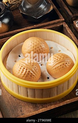 Dim sum - Bun pâtissier Bao brun traditionnel de Chine du Sud rempli de crème de noix, pain de noix Banque D'Images
