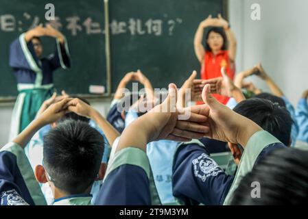 Jinan, province chinoise du Shandong. 12 juin 2023. Les élèves apprennent à faire le salut traditionnel chinois dans une salle de classe confucéenne à Qufu City, dans la province du Shandong, dans l'est de la Chine, le 12 juin 2023. Crédit : CAO Junbo/Xinhua/Alamy Live News Banque D'Images