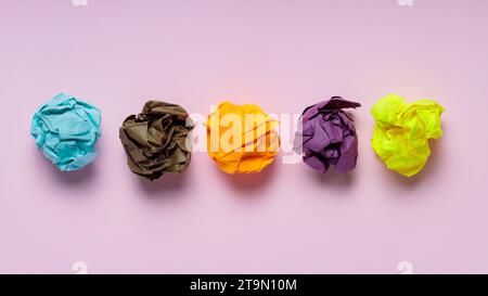 Boules de papier colorées froissées sur fond rose, idée créative et concept d'inspiration Banque D'Images