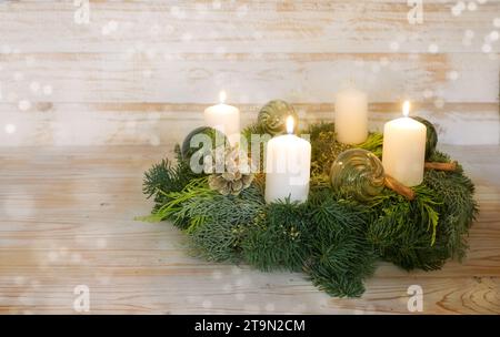 Troisième AVENT, couronne d'AVENT naturel avec des bougies blanches, arbre sont allumés, boules de Noël vertes en verre, pommes de pin et cannelle, fond en bois avec s. Banque D'Images