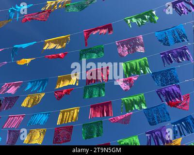 Des drapeaux/bannières colorés de papel picado sont suspendus dans le ciel bleu à Oaxaca, au Mexique Banque D'Images