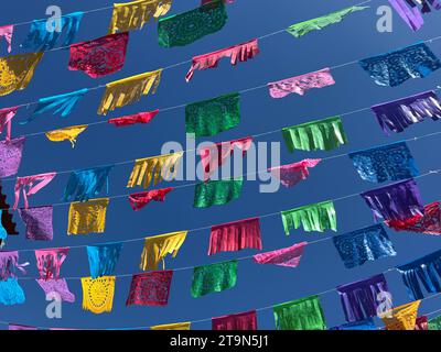 Des drapeaux/bannières colorés de papel picado sont suspendus dans le ciel bleu à Oaxaca, au Mexique Banque D'Images