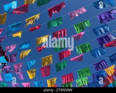 Des drapeaux/bannières colorés de papel picado sont suspendus dans le ciel bleu à Oaxaca, au Mexique Banque D'Images