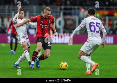 Milan, Italie. 25 novembre 2023. Tommaso Pobega de l'AC Milan (C), Arthur Melo (L) et Fabiano Parisi de l'ACF Fiorentina (R) vus en action lors du match de football Serie A 2023/24 entre Milan et Fiorentina au stade San Siro. Score final ; Milan 1:0 Fiorentina. (Photo de Fabrizio Carabelli/SOPA Images/Sipa USA) crédit : SIPA USA/Alamy Live News Banque D'Images