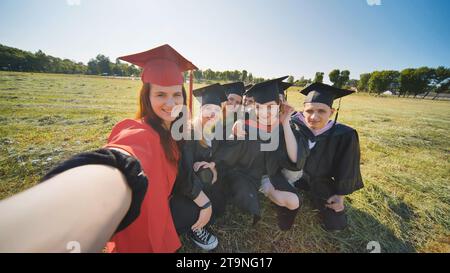 Les anciens élèves du collège prennent des selfies dans le pré. Banque D'Images