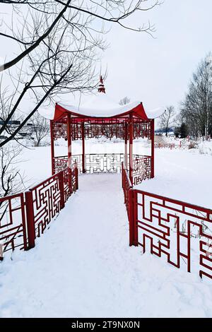 Gazebo rouge de style japonais le jour de l'hiver. Pavillon chinois dans le parc enneigé en hiver. Endroit pour se reposer et se détendre. Banque D'Images