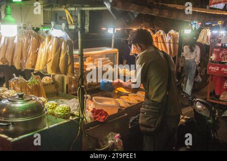 Un cambodgien cuisine des crêpes sucrées la nuit pendant le Festival de l'eau cambodgien, Phnom Penh, Cambodge. © Kraig Lieb Banque D'Images