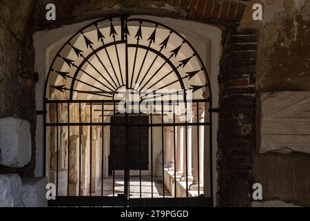 Porte fermée en fer forgé menant au couloir arqué avec des colonnes des deux côtés Banque D'Images