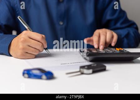 Homme signant l'accord de contrat de document d'assurance automobile. Acheter ou vendre un véhicule neuf ou d'occasion. Banque D'Images