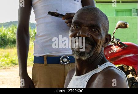 Un travailleur de la canne à sucre pose pour une photo de coupe de cheveux dans une batey, ou communauté de Central Romana, à El Seibo, en République dominicaine, le 21 novembre 2023. Les bateyes abritent les travailleurs de la canne à sucre et leurs familles. La plupart des résidents de ces communautés sont soit des immigrants haïtiens sans papiers, soit des Dominicains dénationalisés d'origine haïtienne. Les États-Unis ont empêché Central Romana Corporation, Ltd. D'importer du sucre dans le pays le 23 novembre 2022 après que des allégations de travail forcé aient été portées contre la société. (Photo de Carlos Berríos Polanco/Sipa USA) Banque D'Images