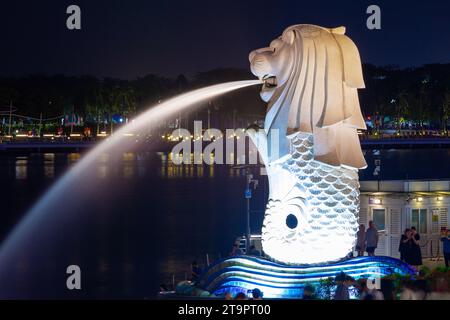 Vue nocturne de la statue de Merlion sur Marina Bay à Singapour, vue depuis le pont piétonnier Jubilee. Banque D'Images