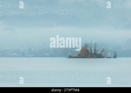 Île dans le brouillard avec ville en arrière-plan Banque D'Images