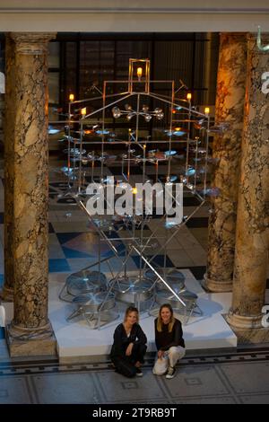 Londres, Royaume-Uni. 27 novembre 2023. L'installation de sapin de Noël V&A 2023 a été conçue par le duo créatif londonien Isabel Helen et célèbre la saison des fêtes par la lumière et le mouvement. Inspirée par le ciel nocturne scintillant, l'installation présente un système complexe de turbines alimentées par le vent, chacune tournant dans sa propre orbite pour alimenter collectivement douze lumières qui se trouvent dans la structure. Crédit : Malcolm Park/Alamy Live News Banque D'Images