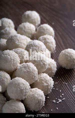 Dans cette photo alléchante, un gros plan de boules de bonbons à la noix de coco gastronomiques vole le projecteur sur un fond sombre. L'allure ronde et douce rend ces t Banque D'Images