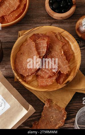 Tranches de porc séché sur une assiette en bois. apéritif à la bière Banque D'Images