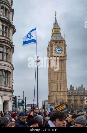 Londres, Royaume-Uni. 26 novembre 2023. Des manifestants pro-israéliens portent un drapeau israélien devant Big Ben lors de la « Marche contre l'antisémitisme » en soutien aux otages pris par le Hamas à Gaza. Crédit : Andy Soloman/Alamy Live News Banque D'Images