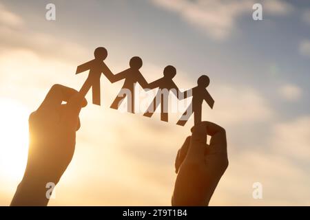 Travail d'équipe et relations. symbolique des chaînes de papier dans la main de la femme. Les gens sont connectés les uns aux autres. Concept de rôle humain. Le concept de travail d'équipe, Banque D'Images