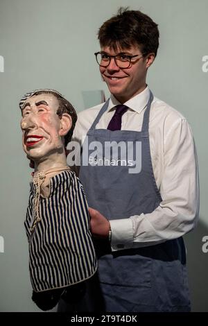 Londres, Royaume-Uni. 27 novembre 2023. Un technicien avec une «marionnette à la main de (Prince) Charles en vêtements de nuit» de Spitting image, circa 1980s, (est. £800 - £1 200) à une avant-première de la vente Rock, Pop & film de Bonham. La vente a lieu dans les galeries Bonhams Knightsbridge le 29 novembre. Crédit : Stephen Chung / Alamy Live News Banque D'Images