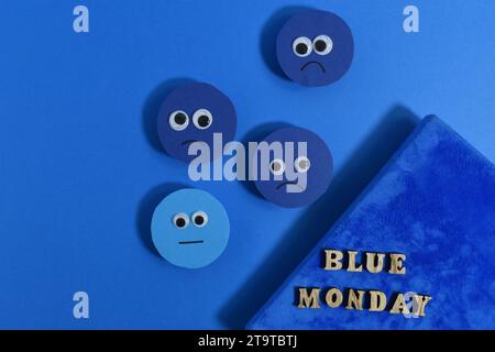 Concept Blue Monday. Visages tristes et journal bleu. Banque D'Images