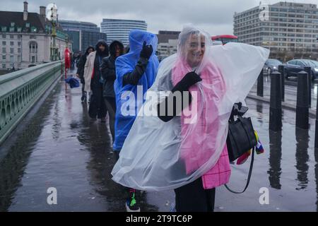 Londres Royaume-Uni. 27 novembre 2023. Les piétons portant des ponchos sur Westminster Bridge sont pris dans de fortes averses. Crédit : amer ghazzal/Alamy Live News . Banque D'Images