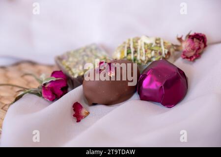 Morceaux de chocolat avec fleurs et roses élégantes sur fond rose et blanc. Concept romantique avec Mock-Up Space pour la personnalisation. Idées pour Valenti Banque D'Images