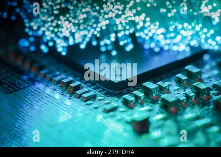 Macro-photographie d'une carte de circuit imprimé avec un processeur et des fibres optiques éclairant la carte Banque D'Images