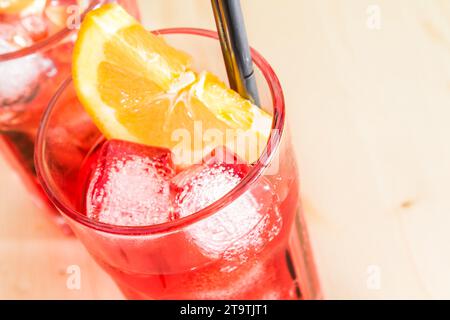 gros plan de verre de spritz apéritif cocktail aperol avec tranches d'orange et glaçons sur table en bois avec espace pour le texte Banque D'Images