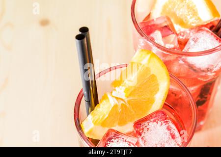 gros plan de verre de spritz apéritif cocktail aperol avec tranches d'orange et glaçons sur table en bois avec espace pour le texte Banque D'Images