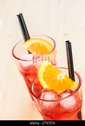 gros plan de verres de cocktail apéritif spritz aperol avec tranches d'orange et glaçons sur table en bois Banque D'Images